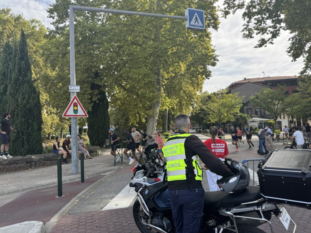 Motard SOMOS sécurisant une intersection lors des 10km du Stade Toulousain