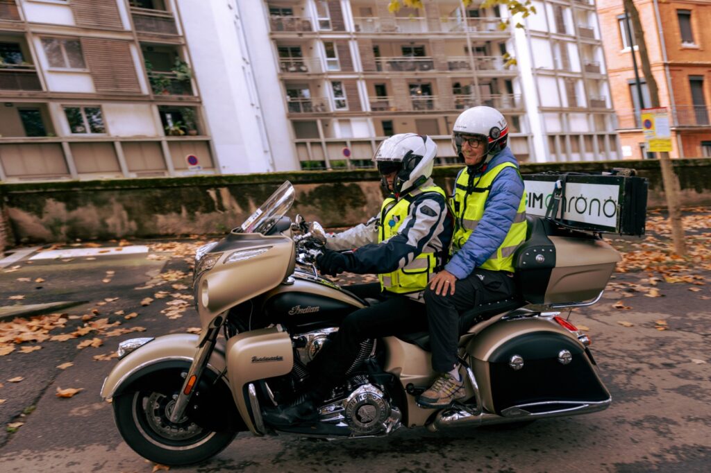 Motard SOMOS transportant un passager lors d'une course à pied